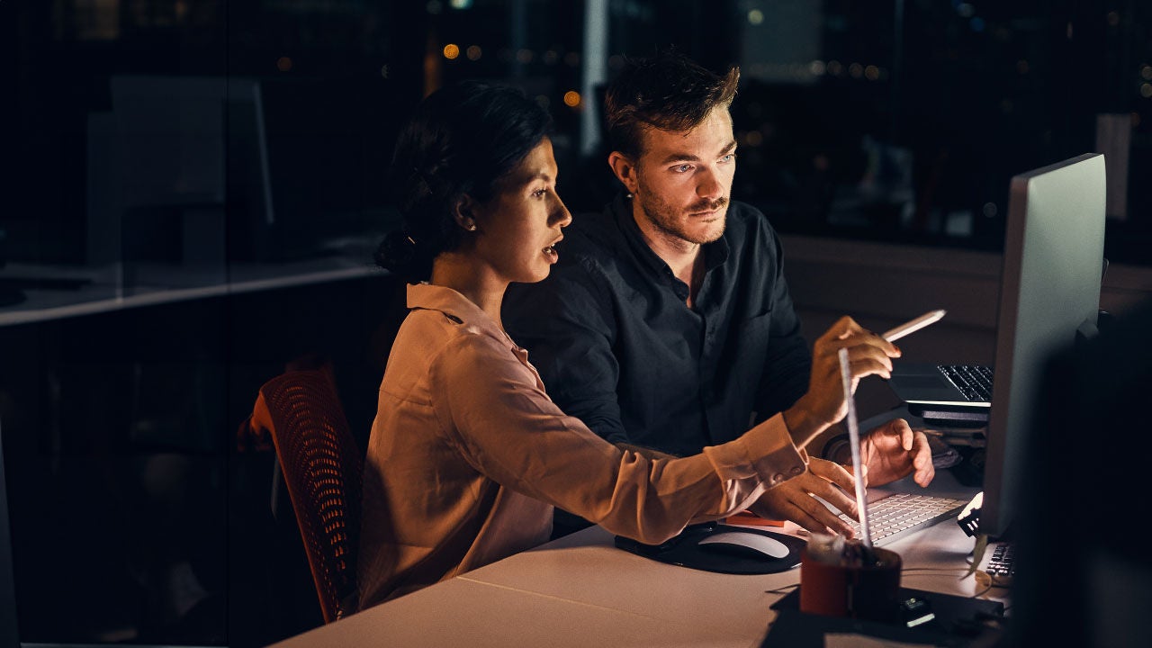 Colleagues working at desk at night.