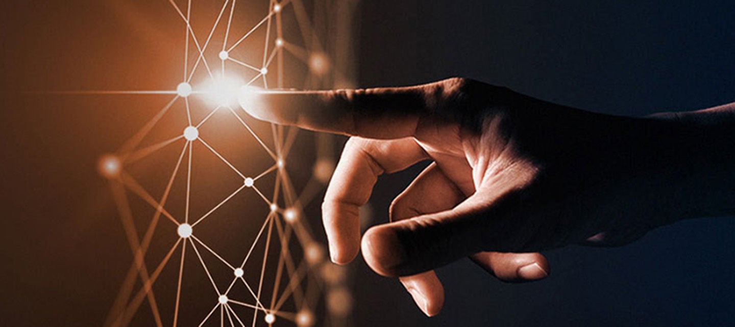 Finger touching an orange glowing superimposed network graphic