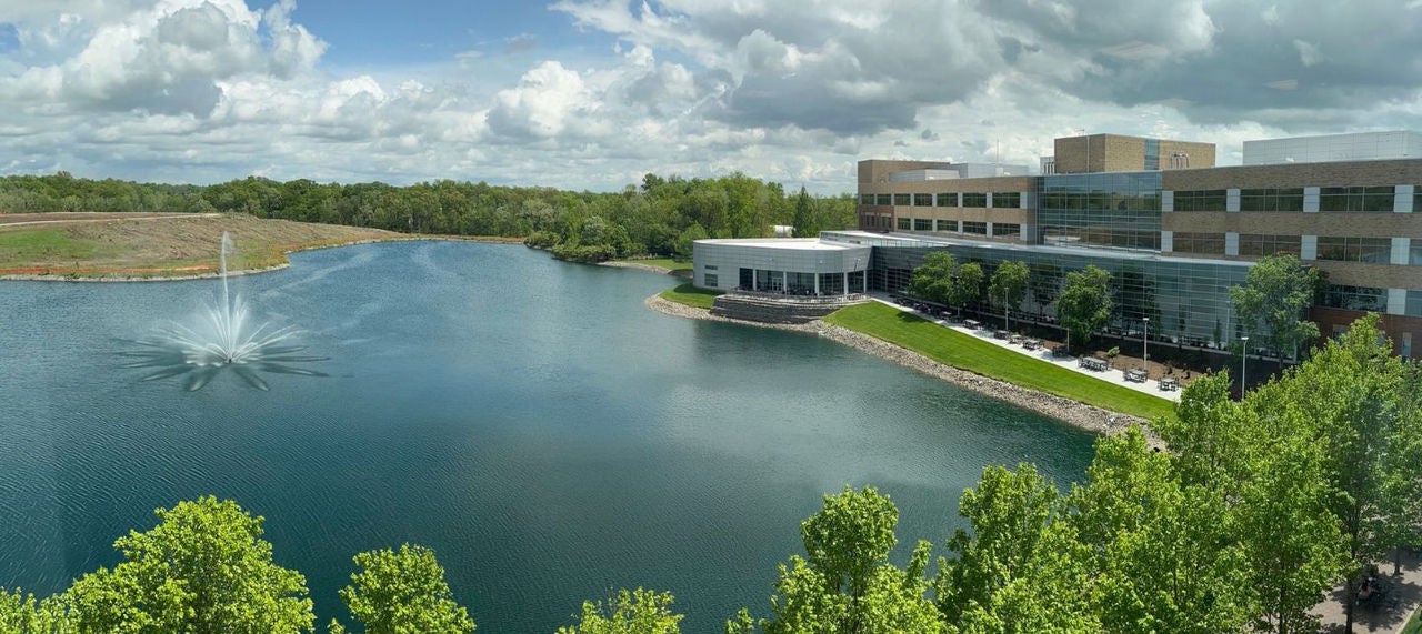 A man sits in a chair and looks at his laptop. 