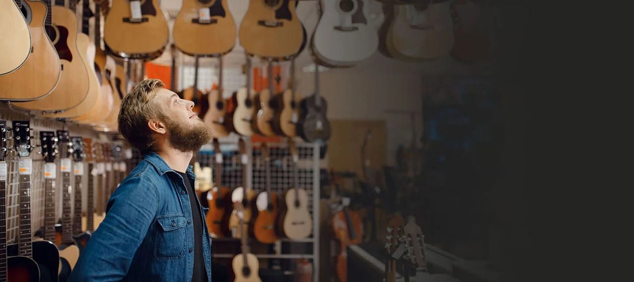 בעלים של חנות גיטרות בחנות שלו.