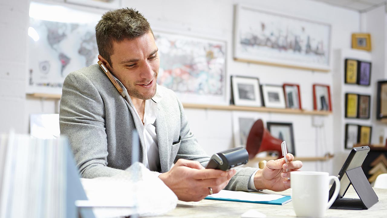 Man on phone with payment terminal