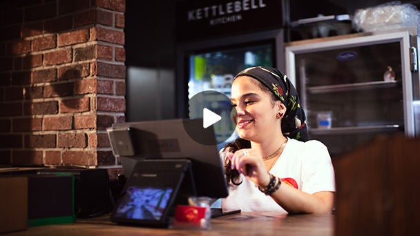 Woman working at register in restaurant.