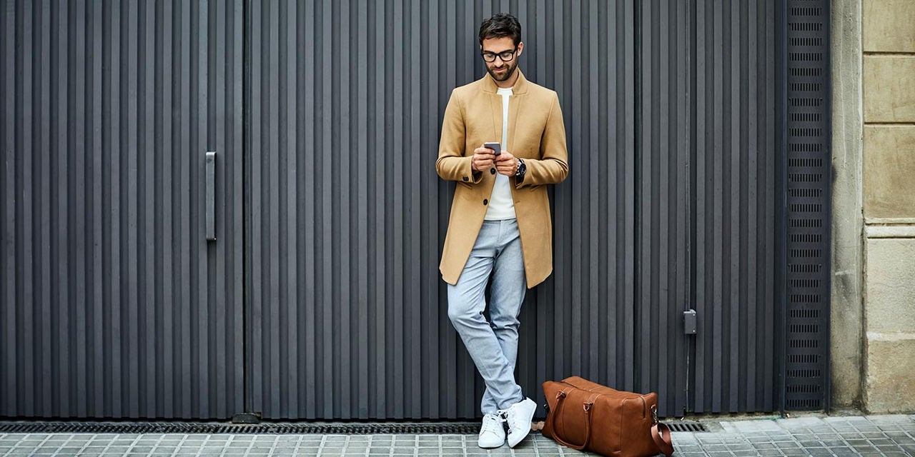 Man with leather bag on smartphone