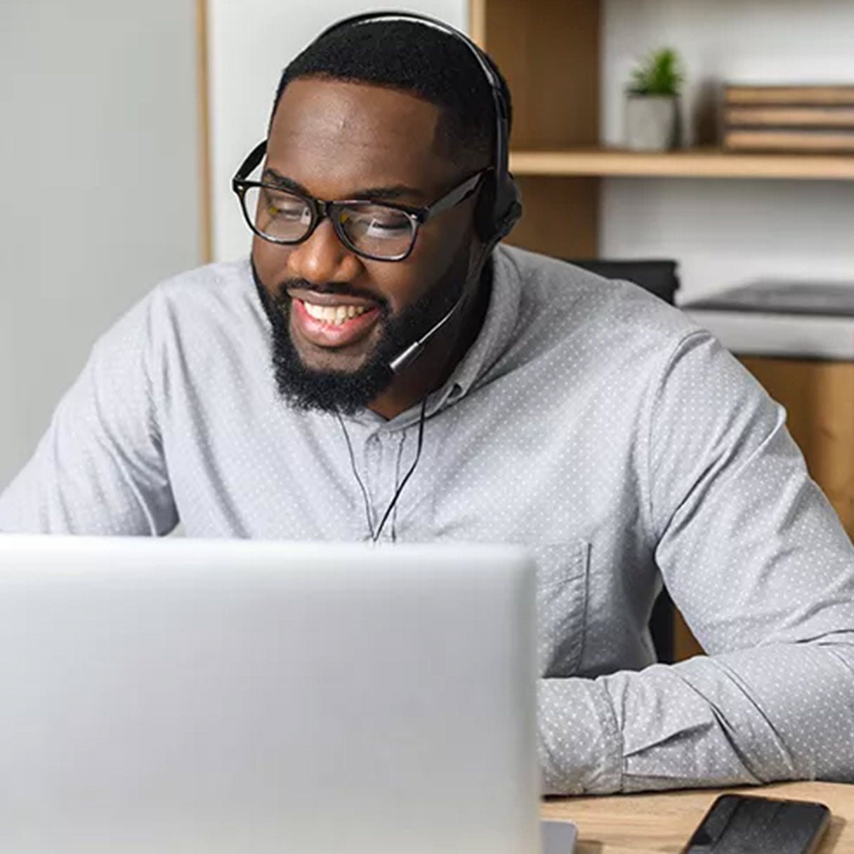 Man wearing headphones working on a laptop.