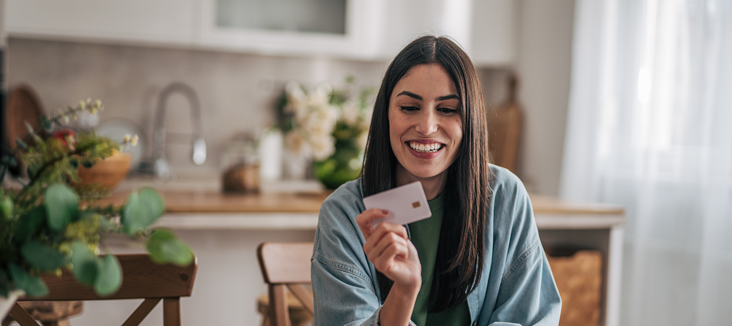 Woman shopping on her computer with her card in hand