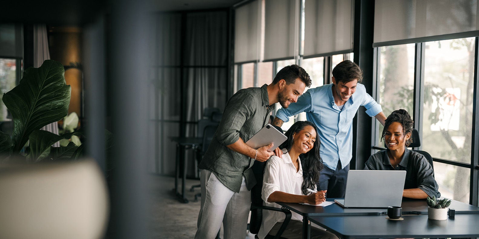 A group of people having a meeting around a desk
