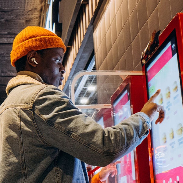 Man operating a digital food kiosk