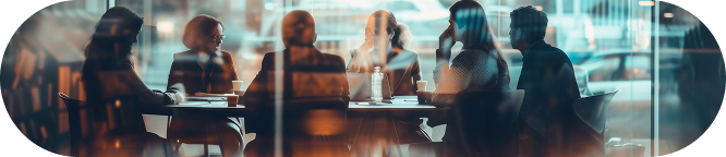 Business team in a lively discussion, seen through a warm, sun-kissed cafe window.