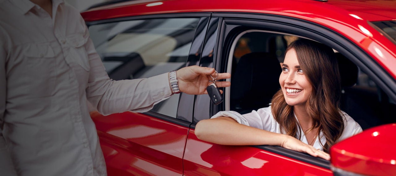 woman receiving keys red car