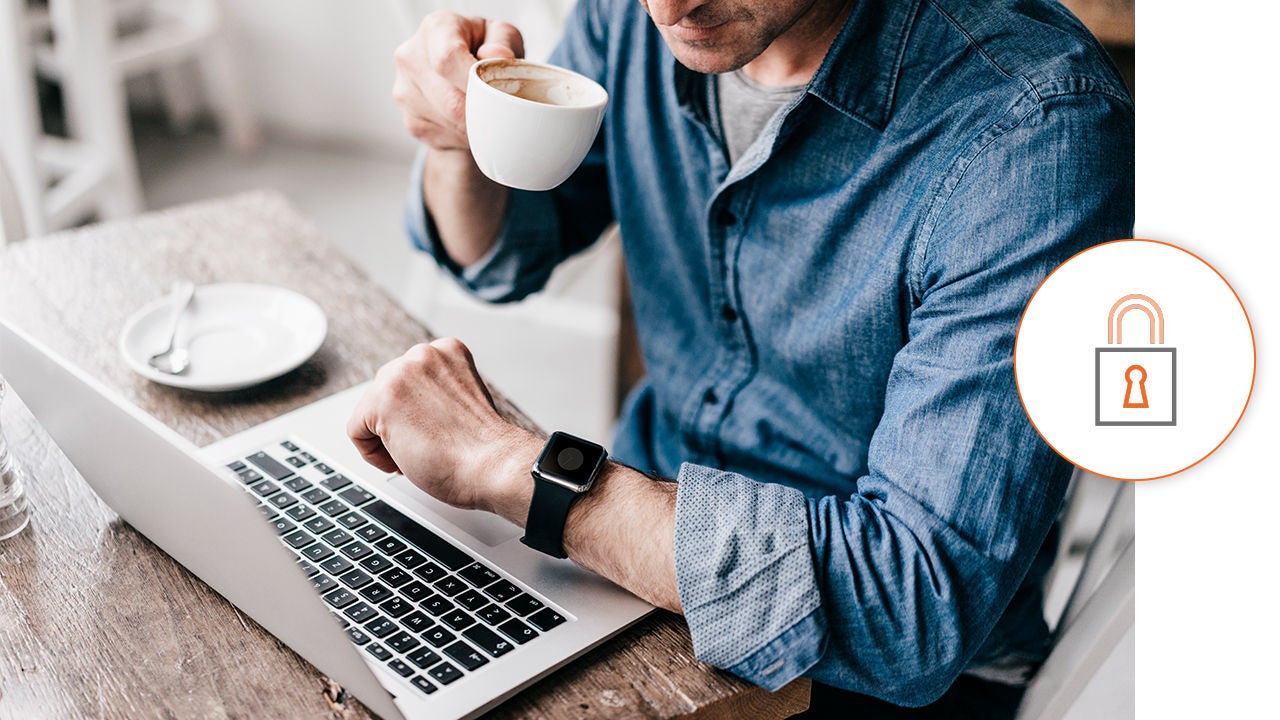 Mann trinkt vor dem Laptop einen Kaffee
