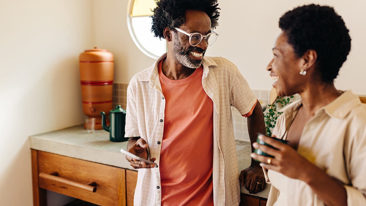 Couple with a mobile phone at home.