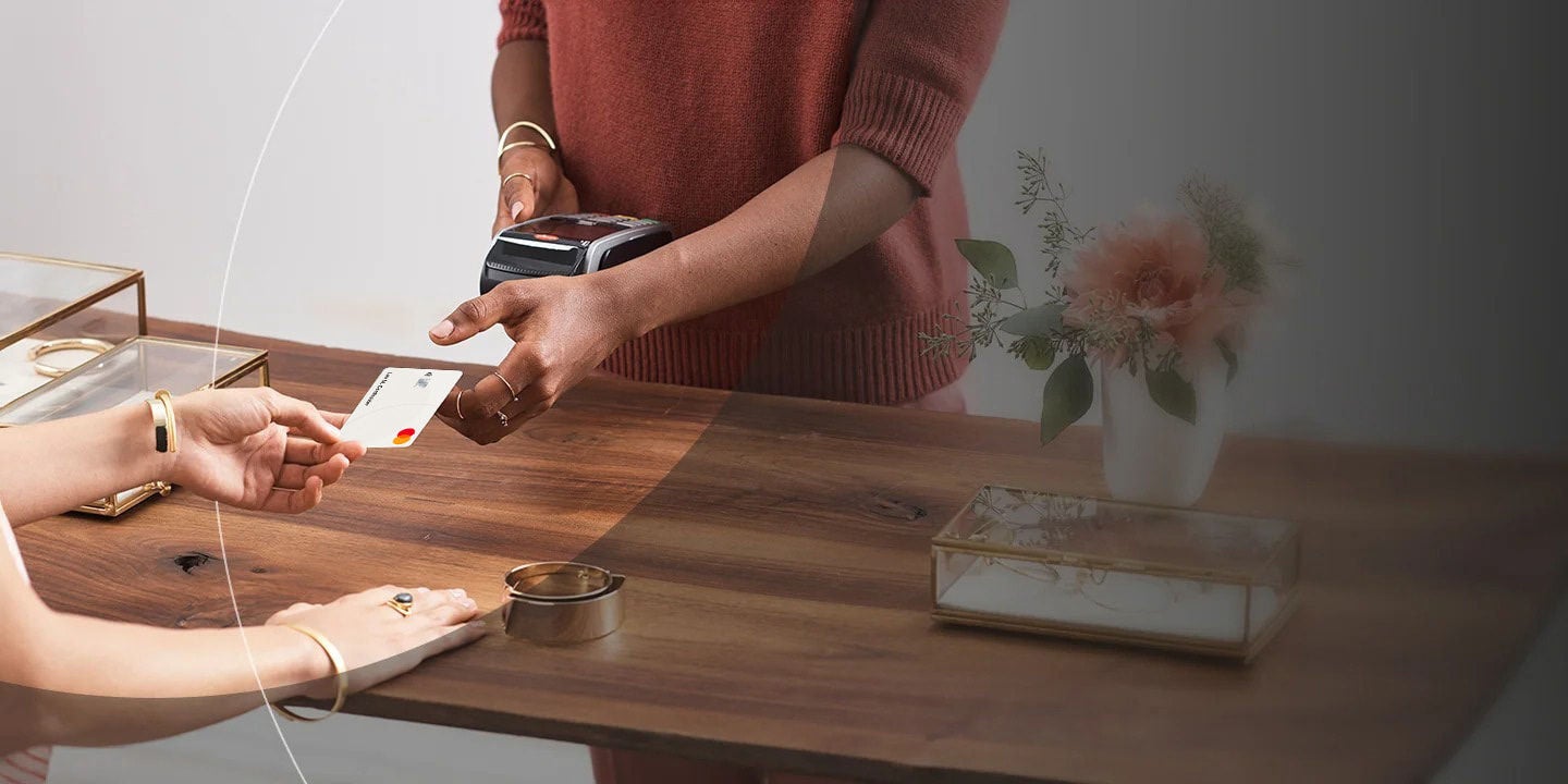 אישה משלמת בחנות באמצעות כרטיס.