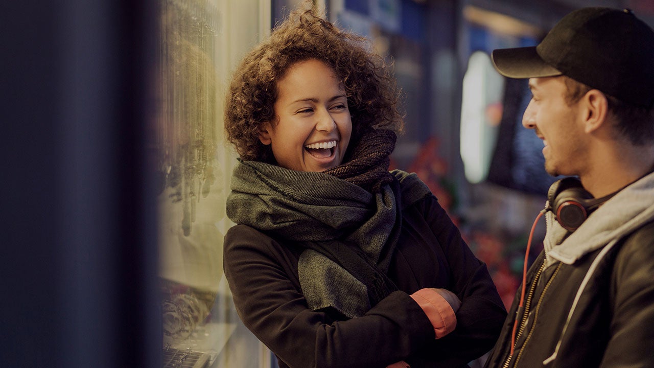 Two friends laughing on a street.