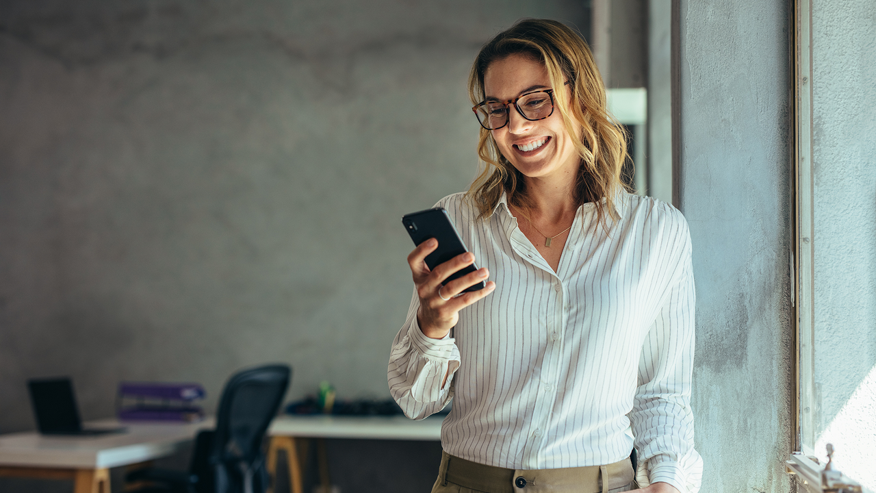 A woman smiling on her phone
