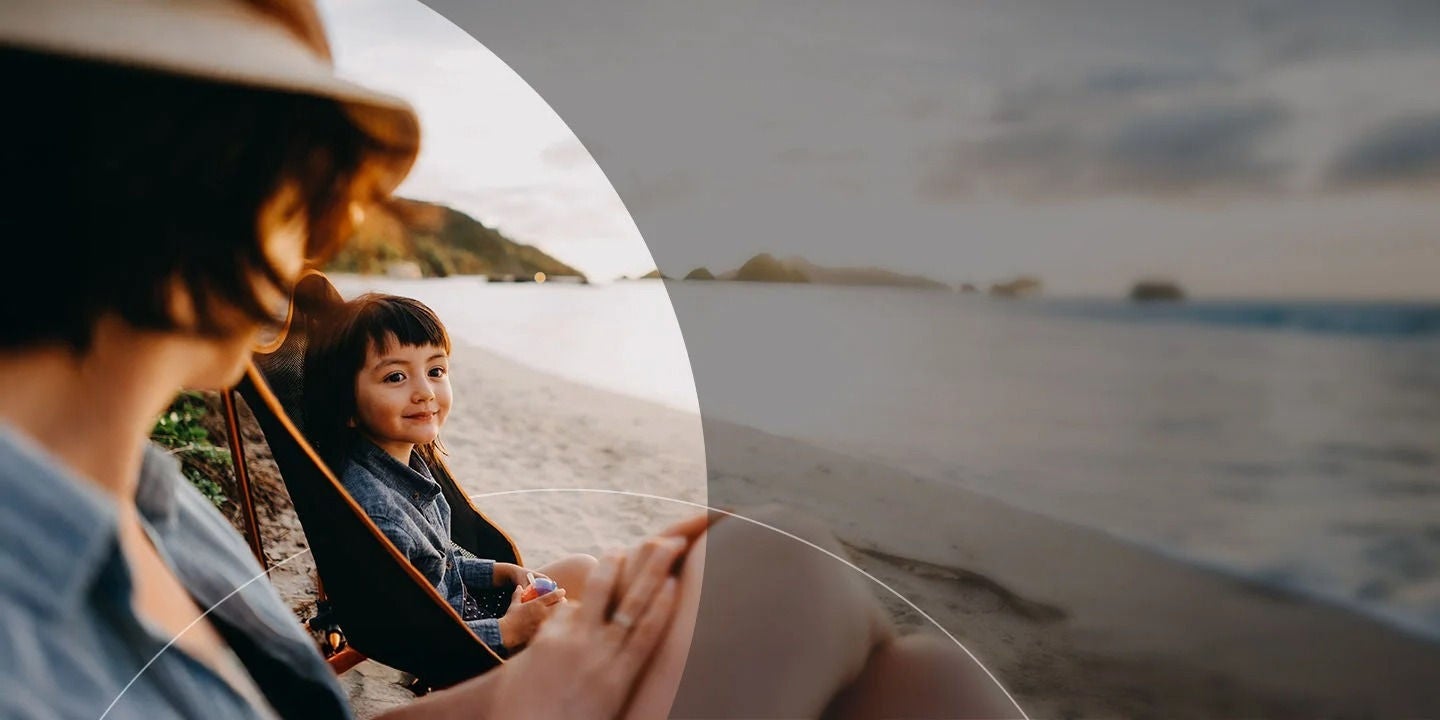 אמא וילד יושבים על חוף.