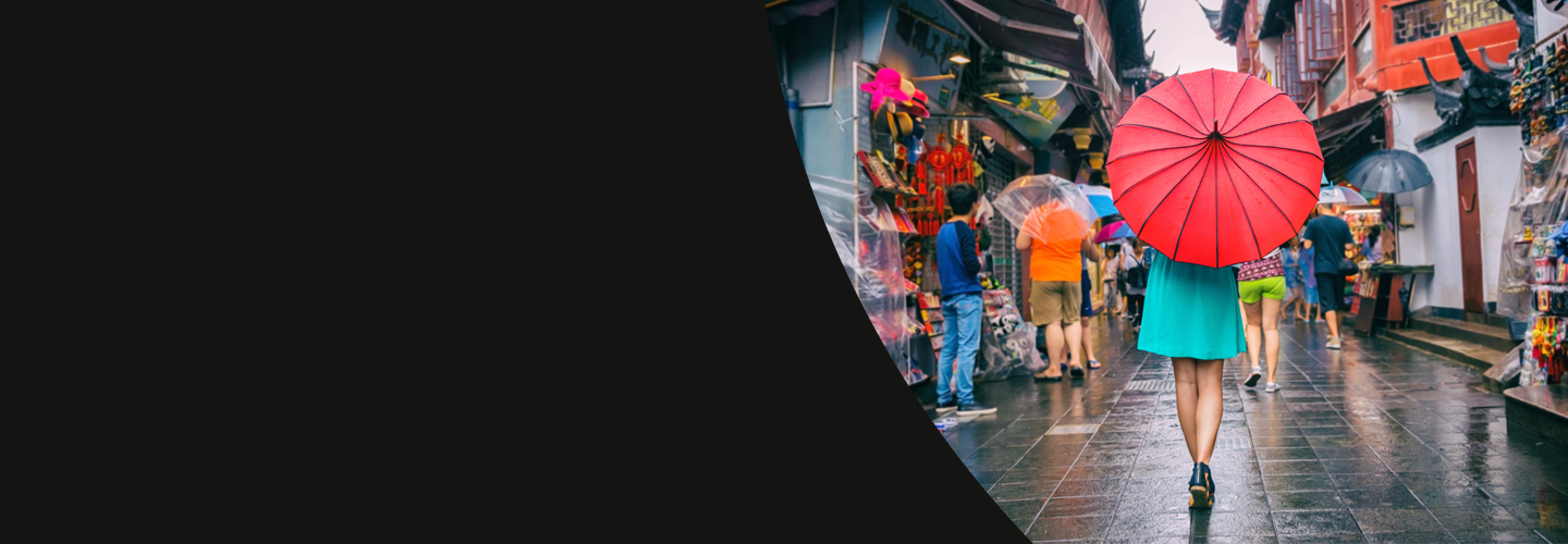 Person walking down a street with a red umbrella