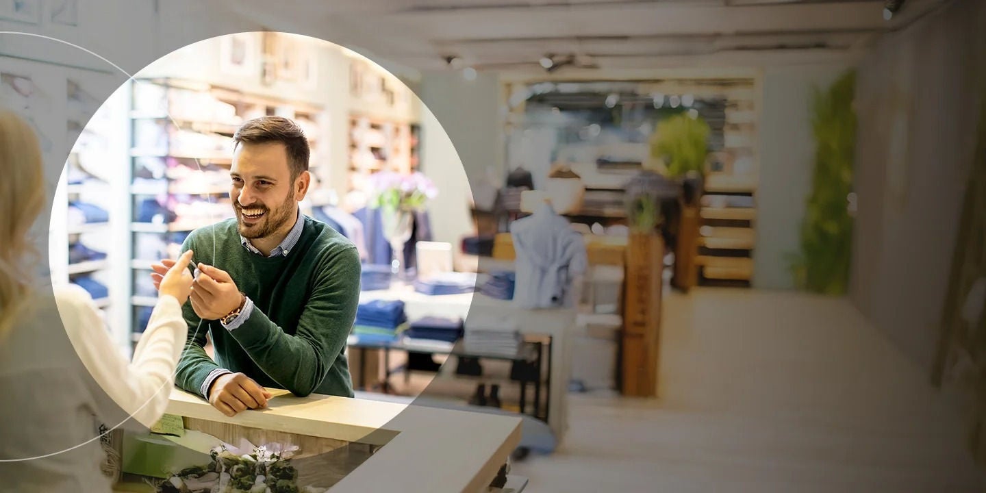 Man paying with credit card in clothing store.