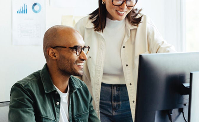 Colleagues working together using a desktop computer