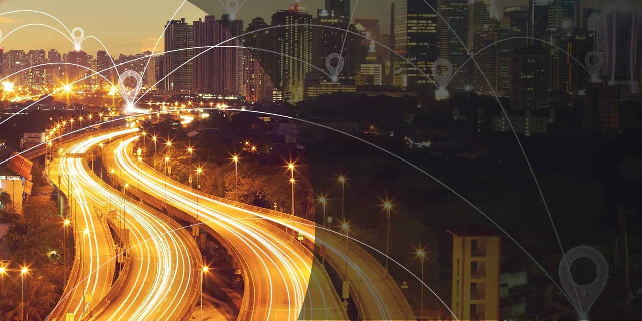 מבט אווירי על עיר חכמה מודרנית הכוללת אדריכלות ידידותית לסביבה, מערכות תחבורה חכמות וקישוריות דיגיטלית.