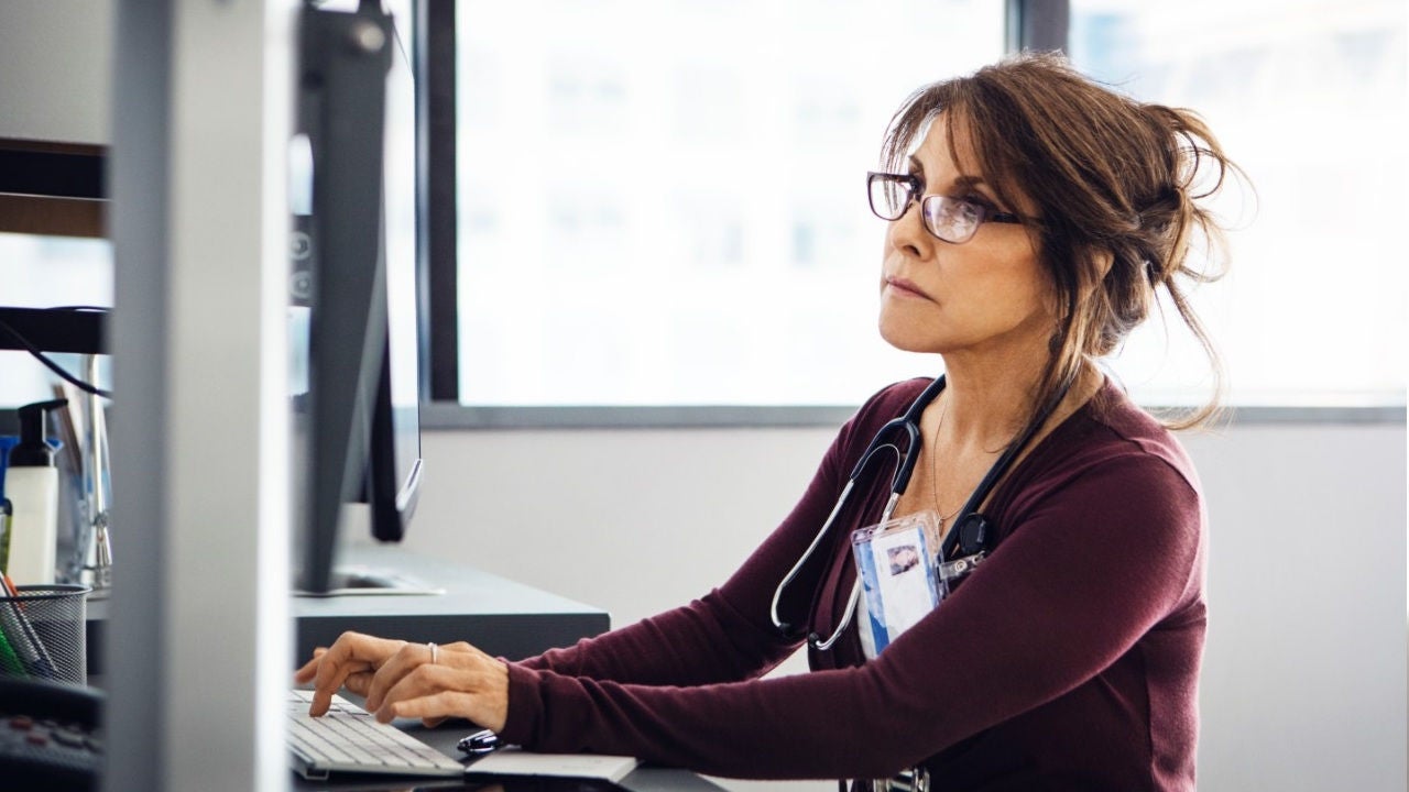 A doctor looks at a computer screen. 