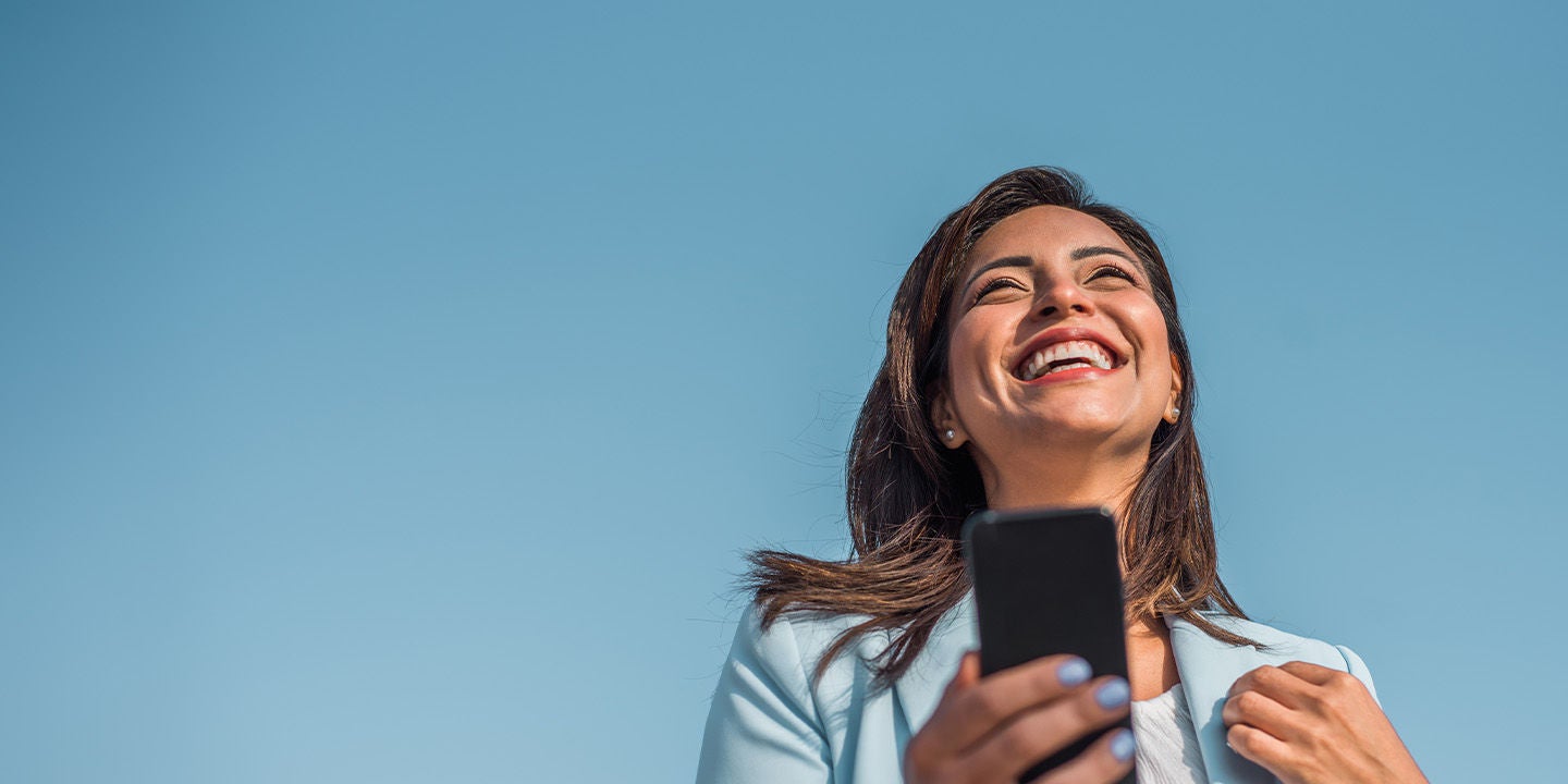Woman smilying happyly using her phone