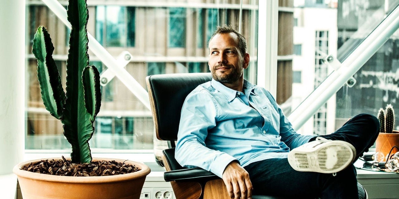 Visma Dinero pose sur une chaise à côté d'une plante