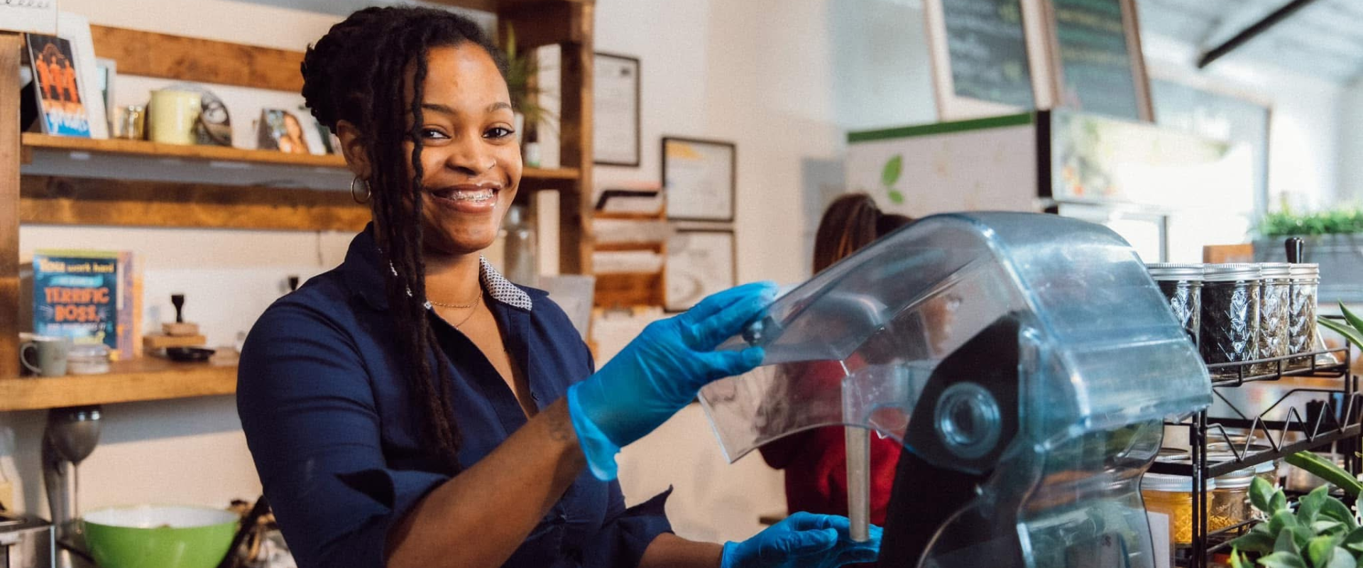 კენეშა ლუისი იღიმის, როდესაც ის სმუზის მაღაზიაში ბლენდერთან დგას. 