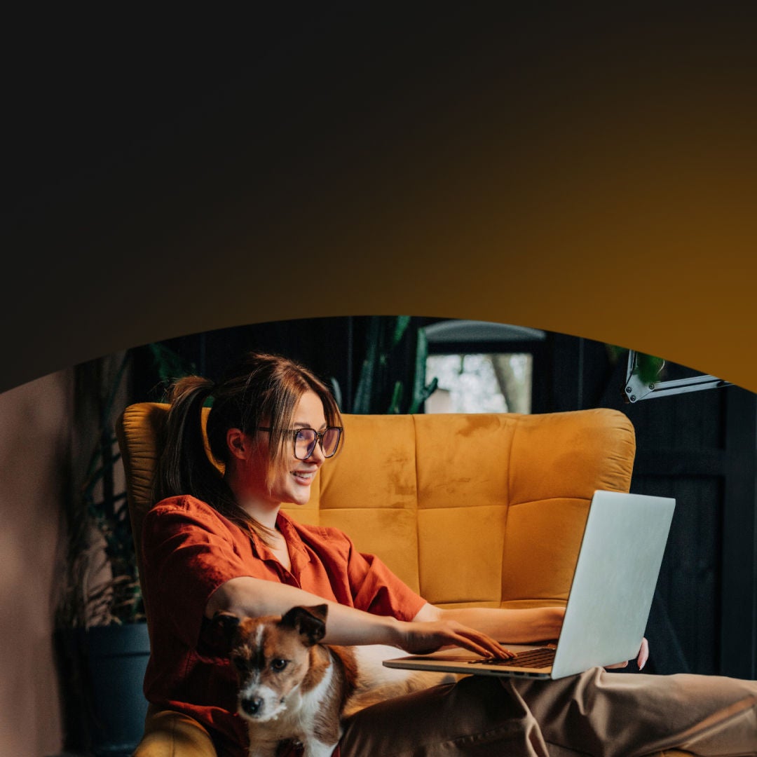 Woman on her laptop with her dog in her lap