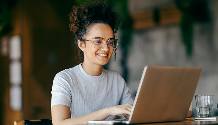 Woman in a coffee shop holding her coffee smiling