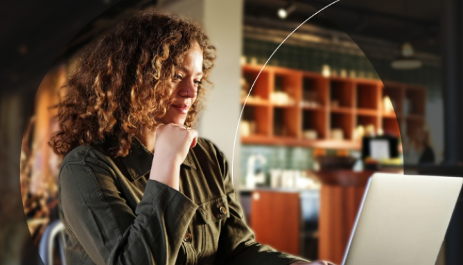 Woman sitting in coffee shop working on laptop