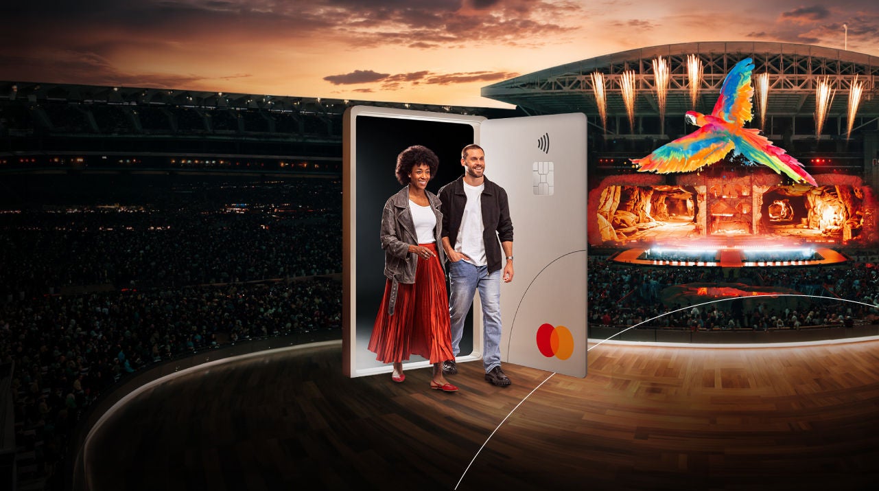 Imagen promocional de Mastercard con una puerta en forma de tarjeta gigante de la que salen dos personas frente a un escenario iluminado para eventos o conciertos.