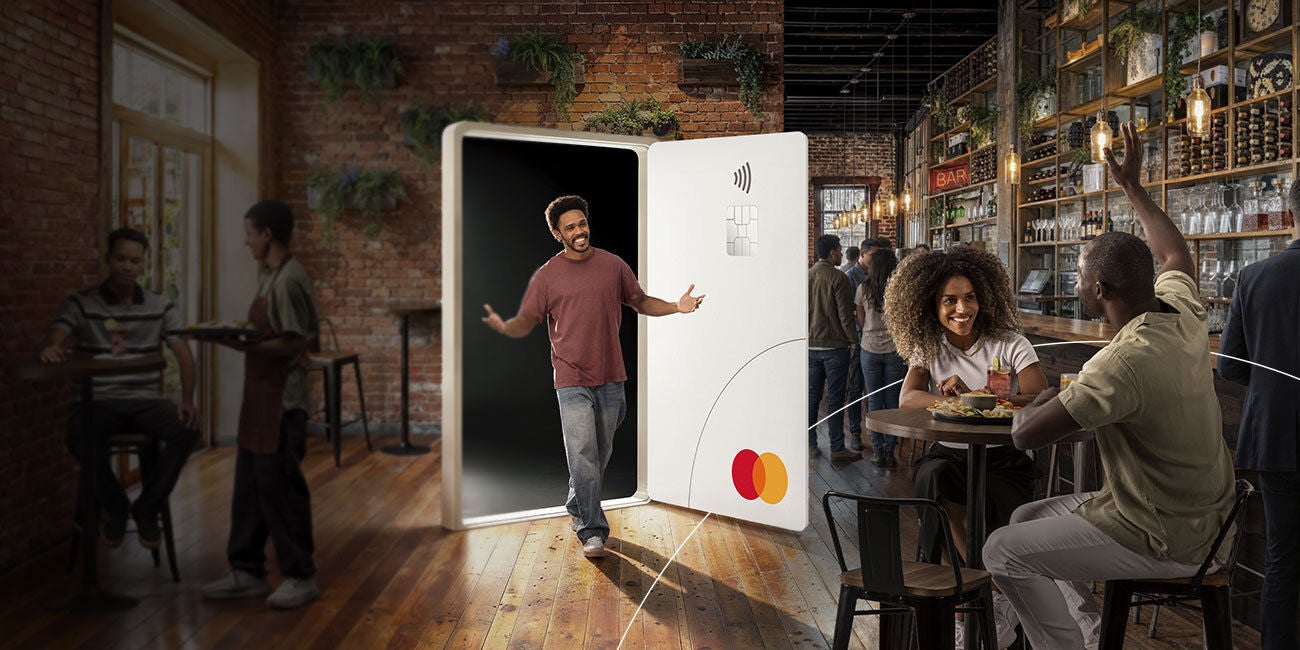 Two smiling people enjoying the benefits of being a Mastercard cardholder.