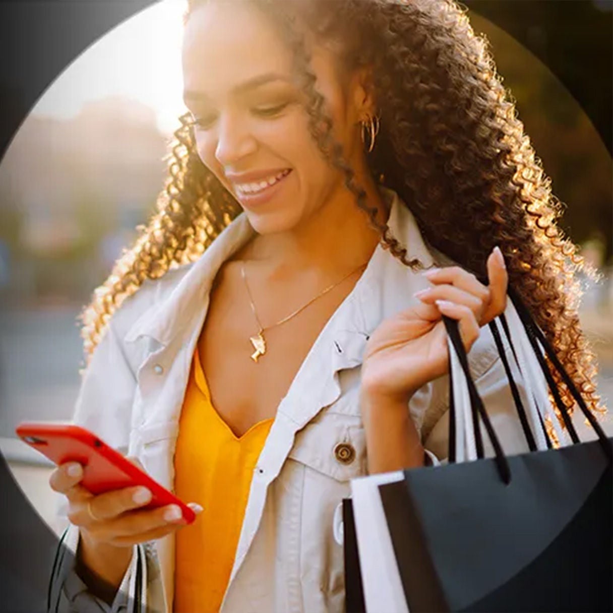 Woman carrying shopping bags looking at her phone