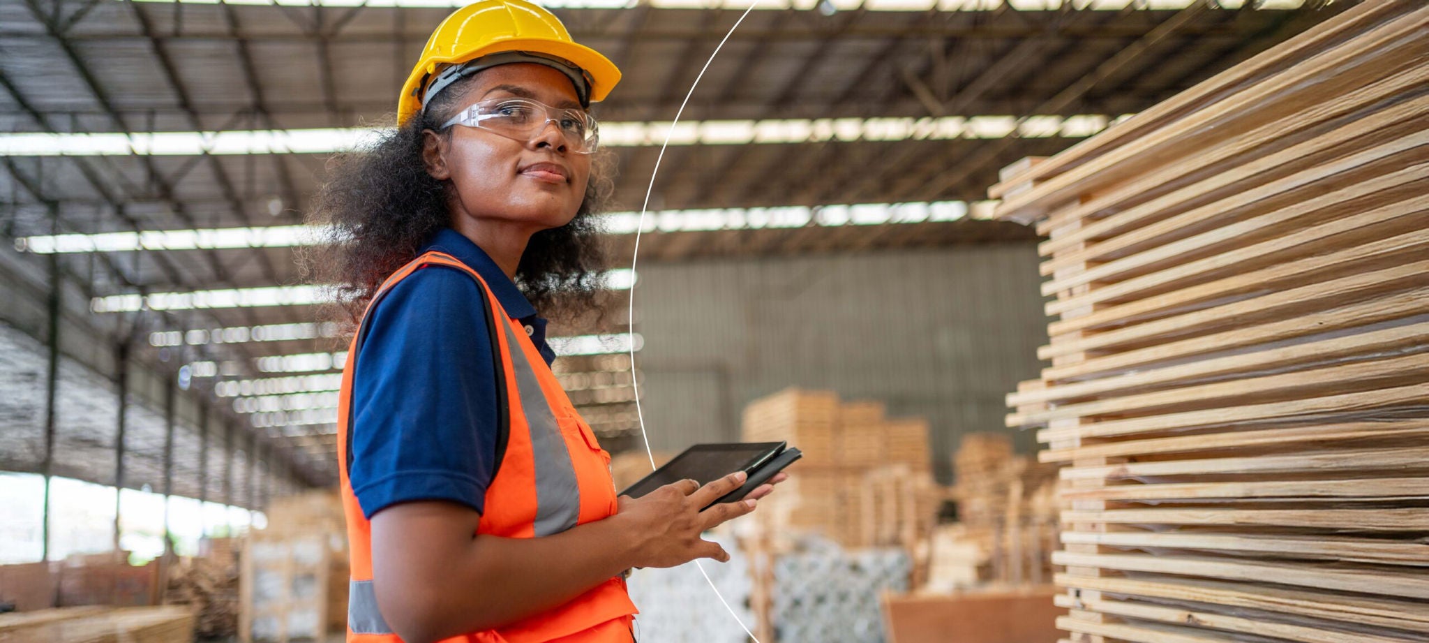 Femme dans une usine avec son appareil mobile regardant au loin