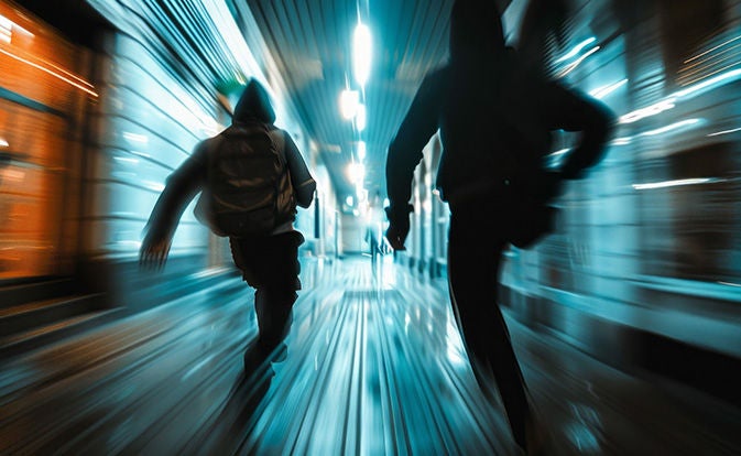 Two people running in a hallway with motion blur to simulate speed