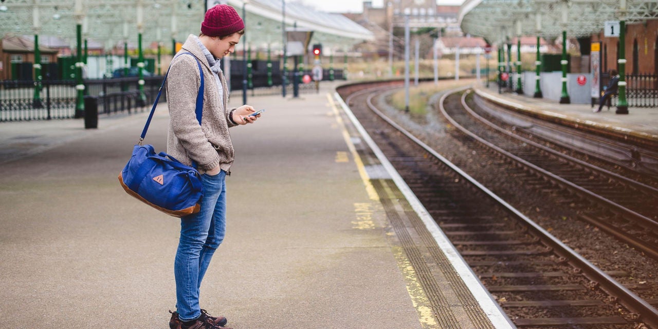 Uomo alla stazione ferroviaria al telefono