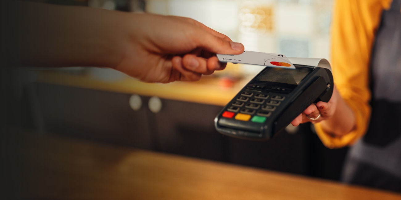 Madre con bebé junto a una computadora portátil y un teléfono móvil.