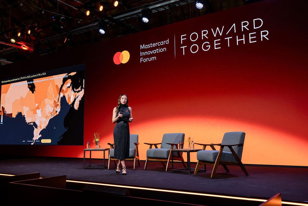 Michelle Meyer prononce un discours d'ouverture avec des données percutantes visibles à l'écran.