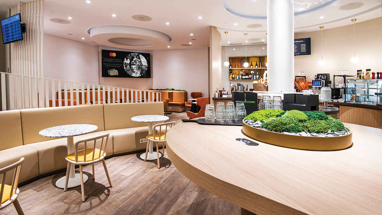 Modern, világos lounge enteriőr kávézóval, ülőhelyekkel és pulttal.