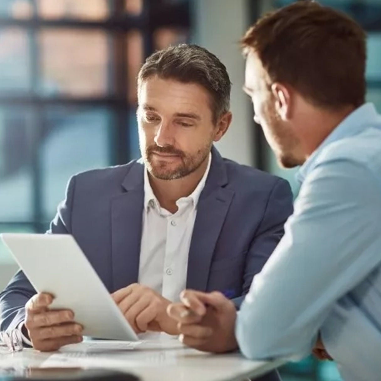 Two professionals reviewing a document together at a table.