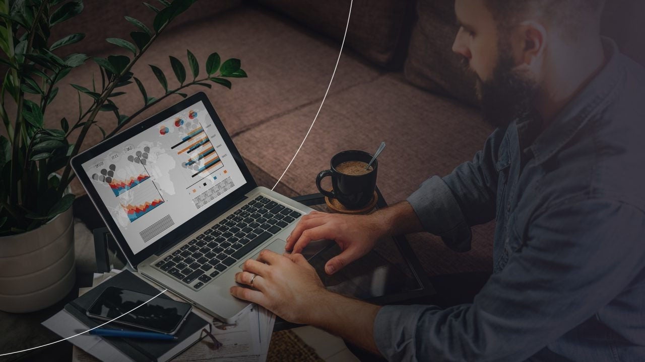 אדם עובד על מחשב נייד המציג גרפים ותרשימים.