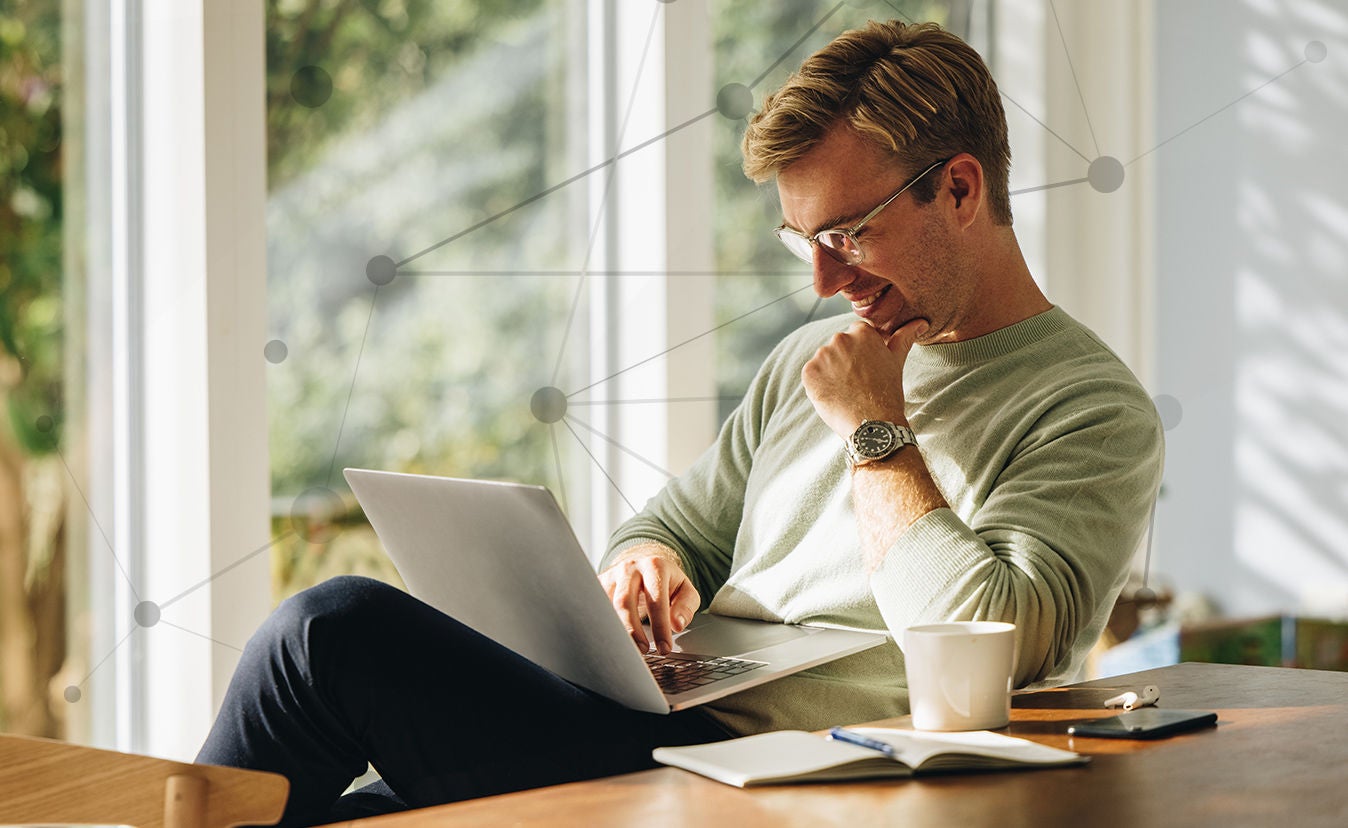 Bărbat zâmbind la laptop, cercetând Avery
