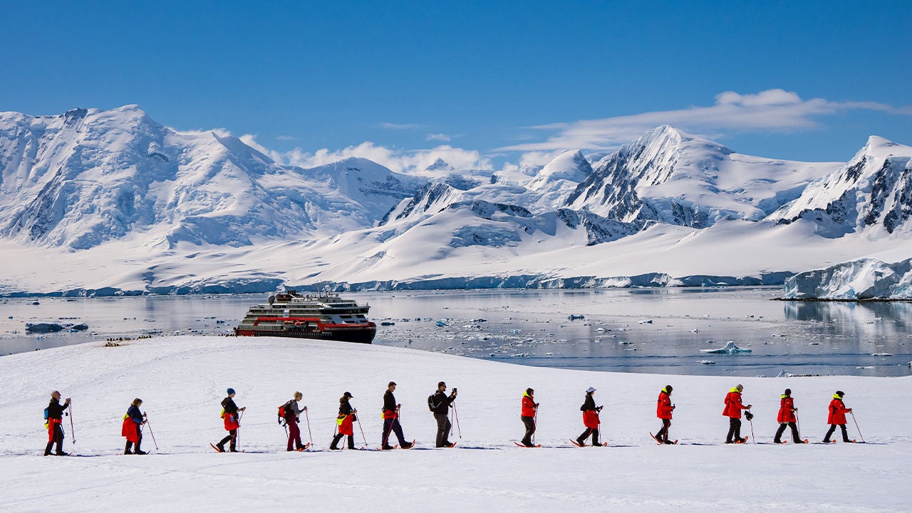 turisti in passeggiata tra neve e ghiacciai