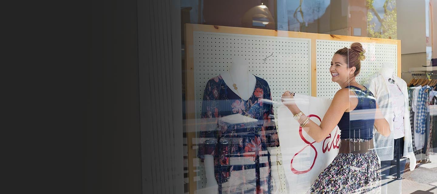 Shop owner decorating a front window.