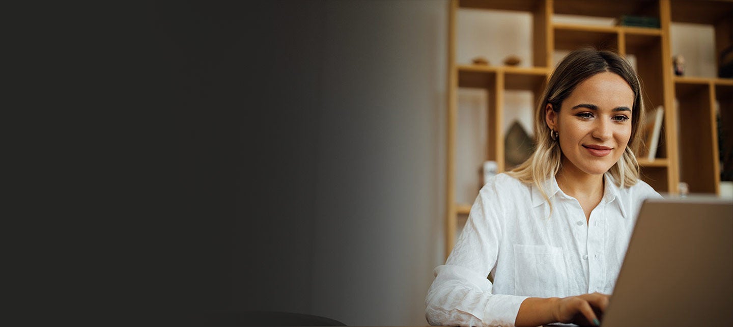 Woman working on a laptop at home office.
