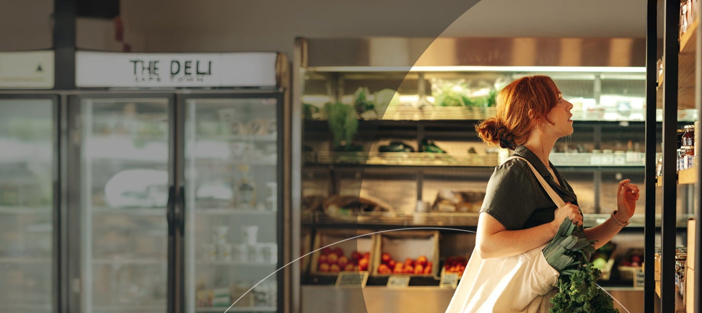 рыжеволосая женщина покупает свежие овощи