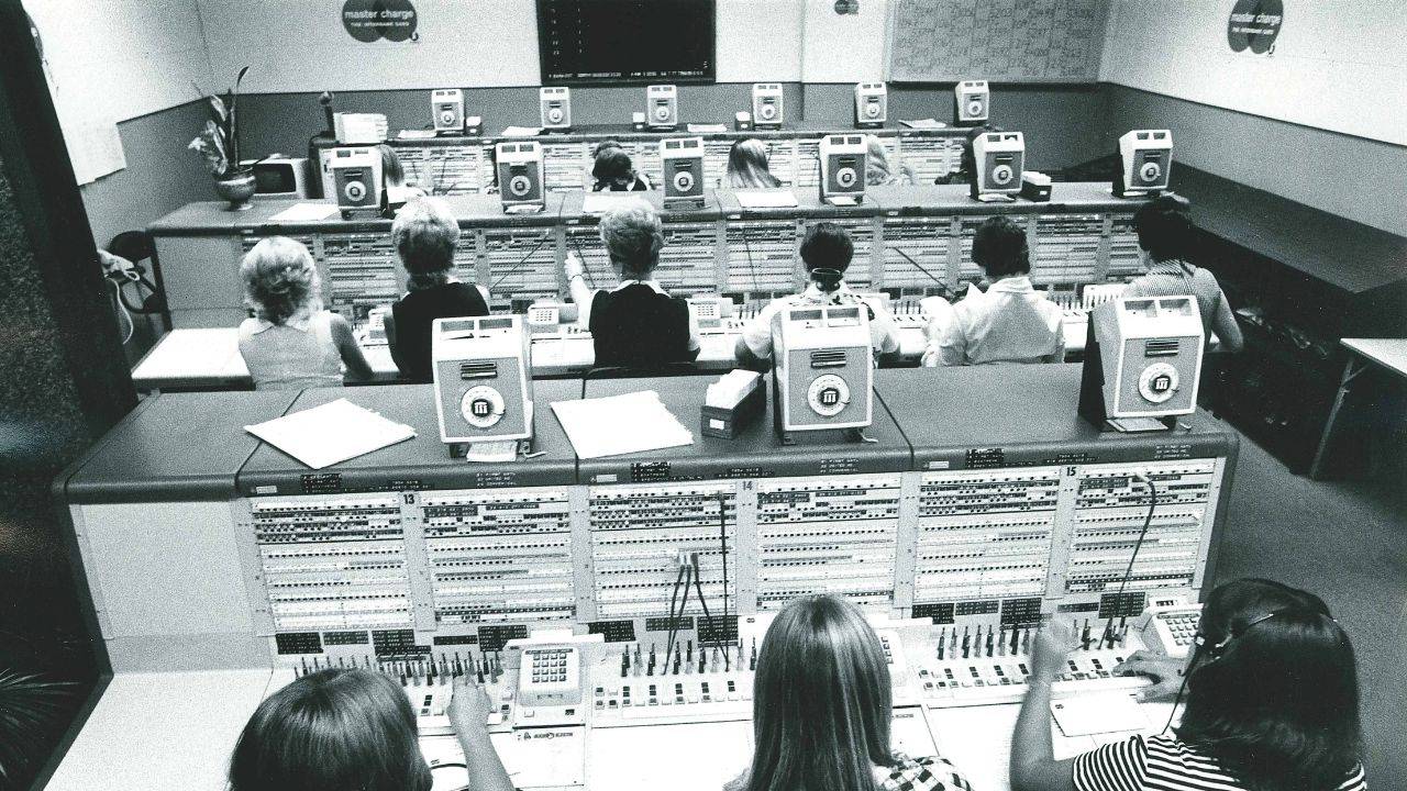 Rows of employees at switchboards that help authorization of credit cards. 