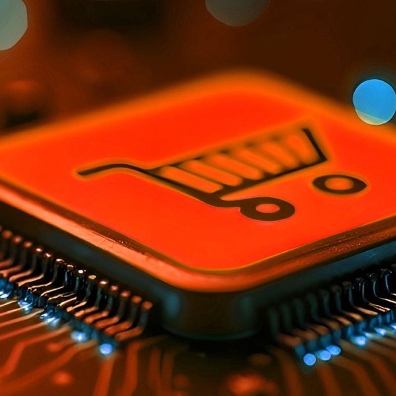 woman holding her hat facing a sunset