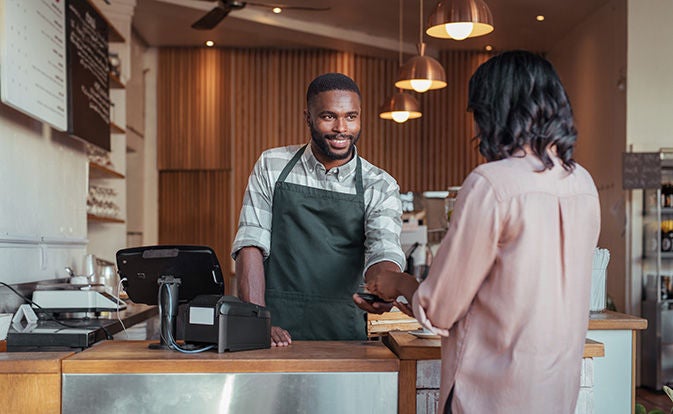 People completing a transaction at a coffee shop