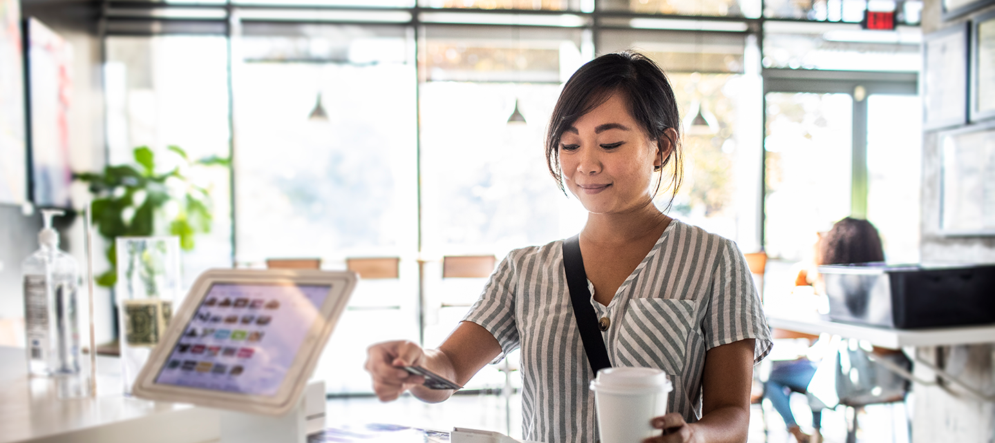 Woman paying with card at a local cafe